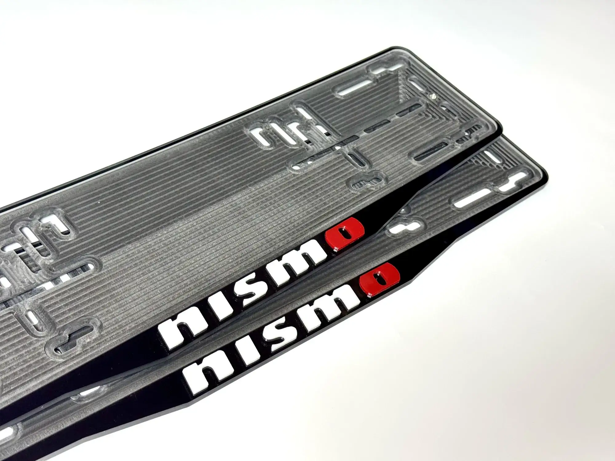 Макро чёрной номерной рамки Nissan nismo с бело-красными объёмными буквами